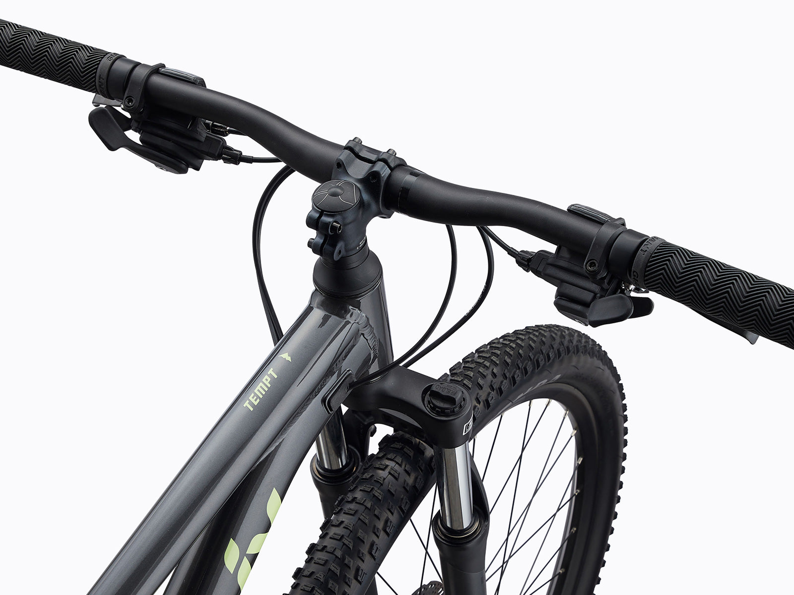 Close-up of a mountain bike's front end, highlighting the handlebars, wheel, and suspension.